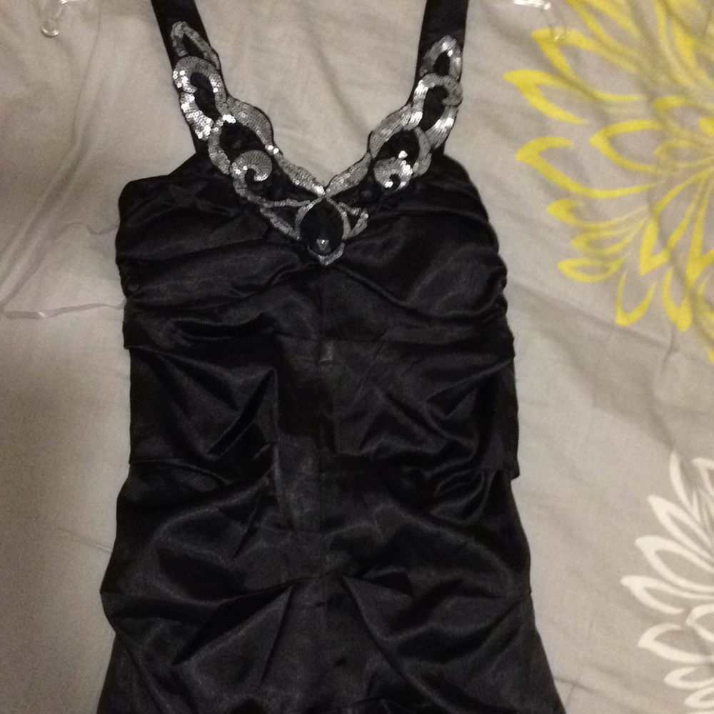 Black dress with sequins and black stones .